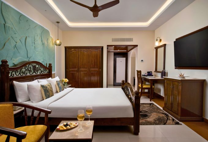 Spacious king bedroom with Indo-Portuguese décor and tropical wall art at Mercure Goa Devaaya Resort Divar Island